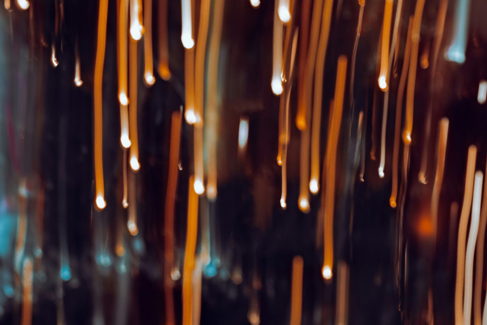 Warm golden sparks of light against a dark background
